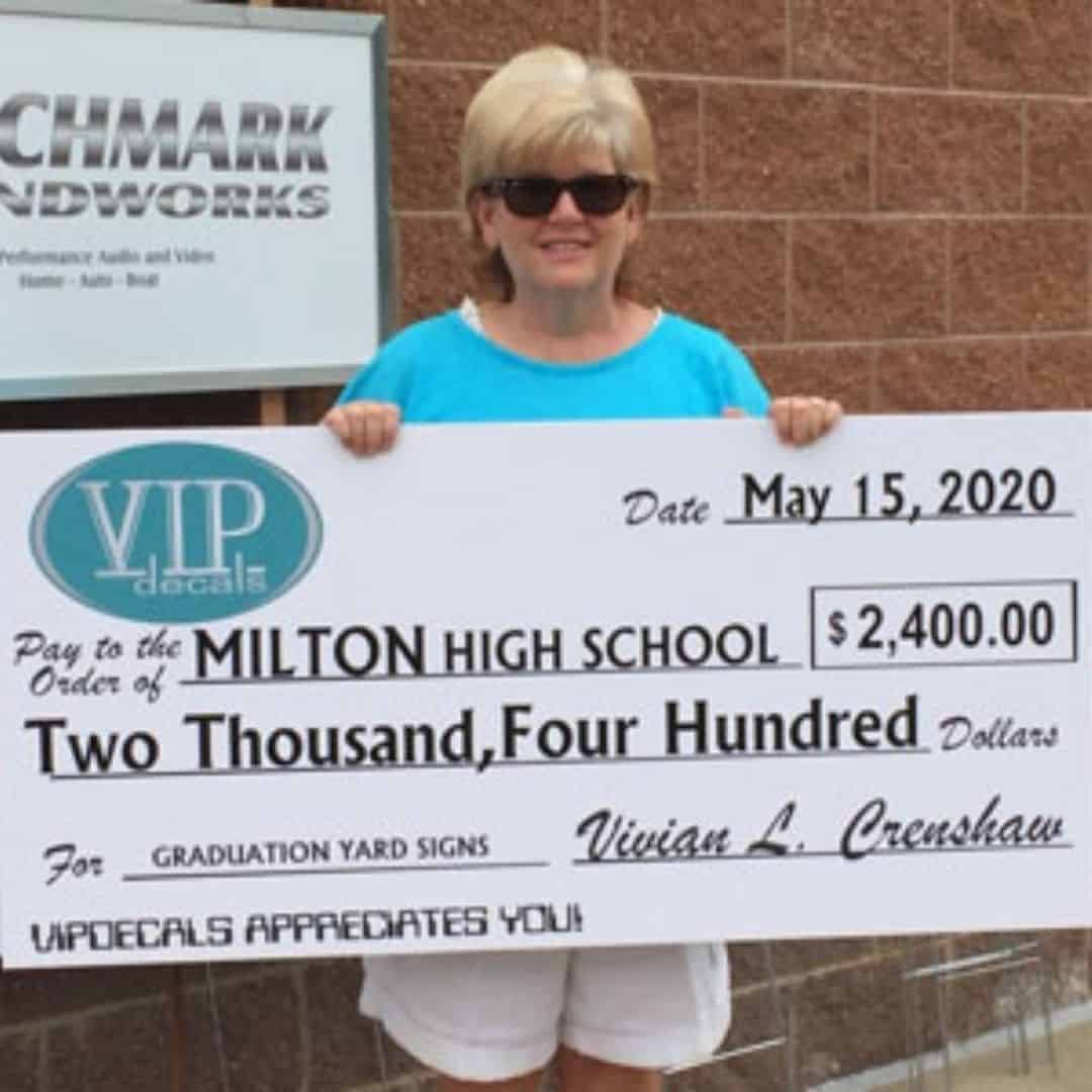 Milton parent holding 2020 high school graduation yard sign fundraiser check